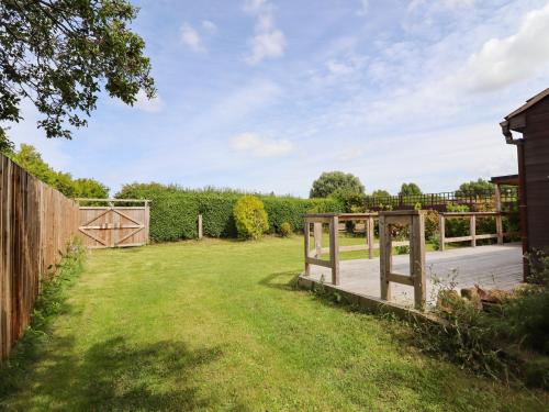 a wooden gate in a yard with a fence at Meols Holiday Lodge in Wirral