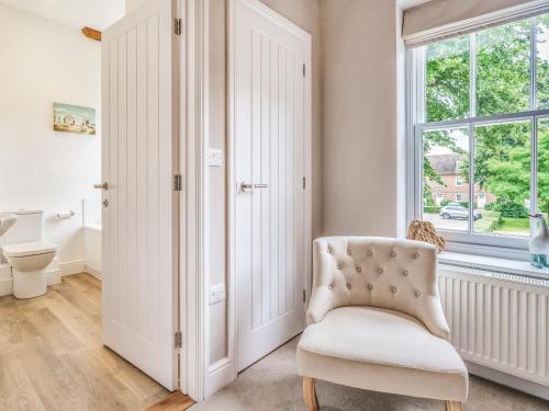 a white chair in a room with a window at Hillcrest, Blythburgh in Blythburgh