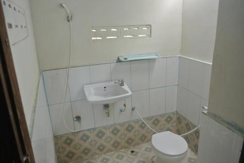 a small bathroom with a toilet and a sink at Tavendang Guesthouse in Don Det