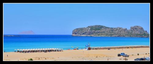 a beach with a bunch of umbrellas and the ocean at Mouri Village in Aïkiryiánnis