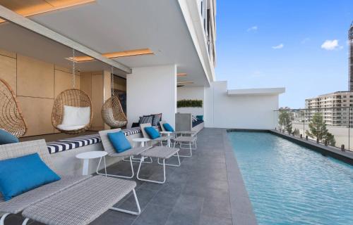 a hotel with a swimming pool and chairs and a building at Elegant and Cozy Top Floor 1BD Apartment at South Bank in Brisbane