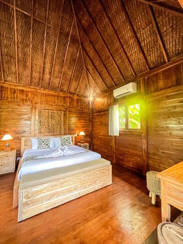 a bedroom with a bed in a wooden room at The Banana’s Kumbe Villa in Tampaksiring
