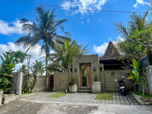 a house with a motorcycle parked in front of it at The Banana’s Kumbe Villa in Tampaksiring
