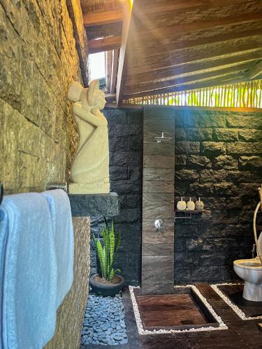 a bathroom with a stone shower and a sink at The Banana’s Kumbe Villa in Tampaksiring