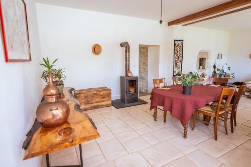 a living room with a table and a wood stove at La colonie - Haut Valromey in Chavillieu
