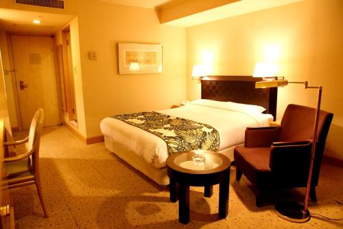 横浜市にあるブリーズベイホテル リゾート&スパのベッドと椅子付きのホテルルーム