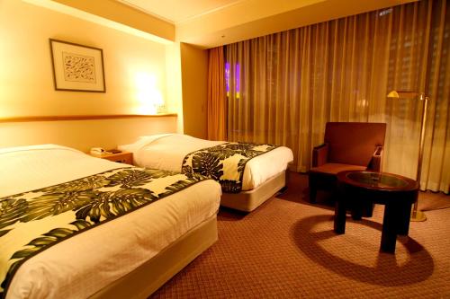 ein Hotelzimmer mit 2 Betten und einem Stuhl in der Unterkunft Breezbay Hotel Resort and Spa in Yokohama