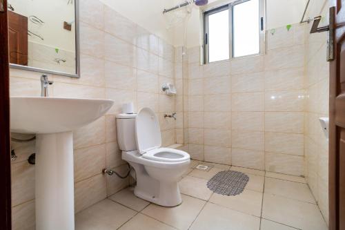 a bathroom with a toilet and a sink at Greatwall in Athi River