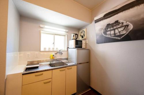 a small kitchen with a sink and a refrigerator at 日向サーフキャンプ202 in Hyuga