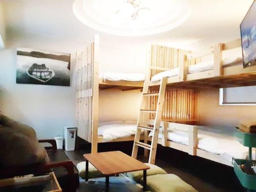 a room with two bunk beds and a couch at 日向サーフキャンプ202 in Hyuga