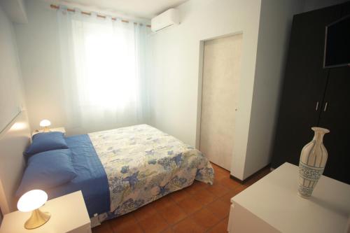 1 dormitorio con 1 cama y un jarrón sobre una mesa en al mare, en Porto Recanati