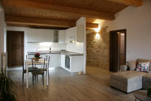 a kitchen and living room with a table and a couch at Maison Rosina con ampia vista in borgo del 1400 in Marsciano