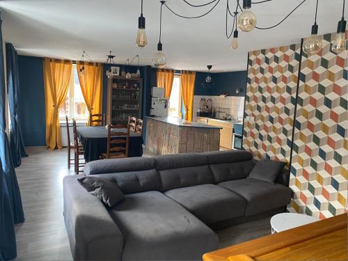 a living room with a couch and a kitchen at Appart 8 personnes le calice in Saint-Maurice-sur-Moselle