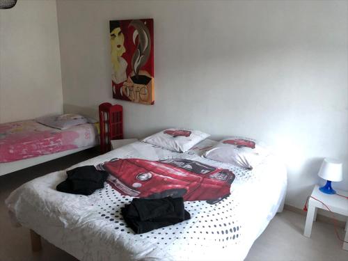 a bedroom with a bed with a red suitcase on it at Appart 8 personnes le calice in Saint-Maurice-sur-Moselle
