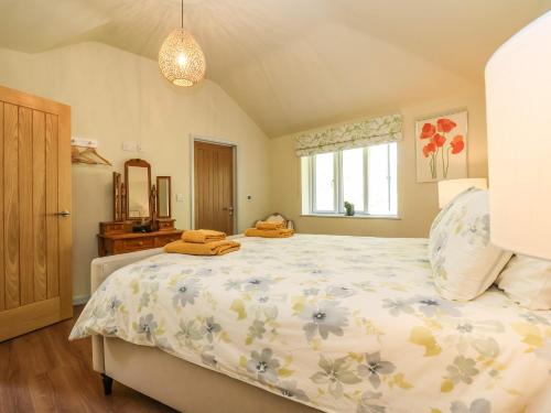 a bedroom with a large bed and a window at Church Farm Barn in Saxmundham