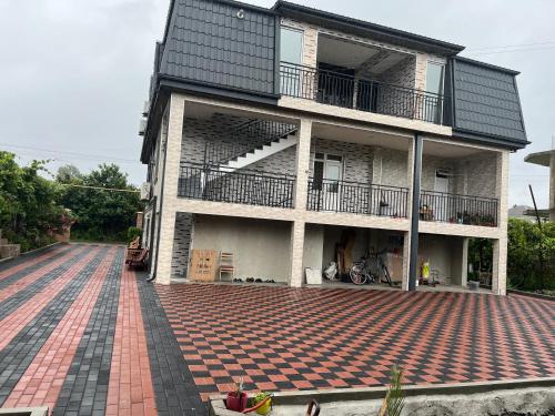 a house with a brick walkway in front of it at Guest House OASI in Batumi