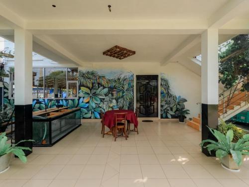 Hotel Blackstone في هامبانتوتا: غرفة طعام مع طاولة وجدار من النباتات