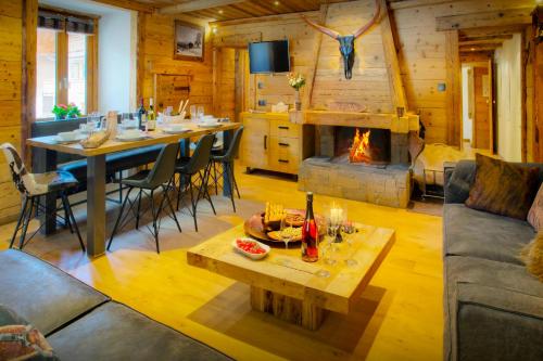 a living room with a table and a fireplace at Chalet Artedaz - OVO Network in La Clusaz