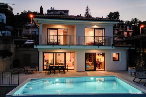 una casa con piscina frente a ella en Villa Norma en Opatija