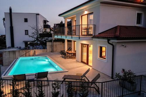 a villa with a swimming pool in front of a house at Villa Norma in Opatija