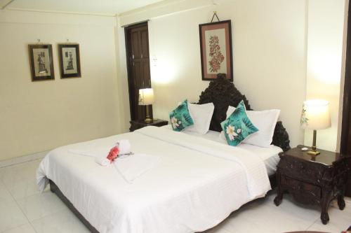 a bedroom with a large white bed with a stuffed animal on it at AESTHETICS - THE HOME STAY in Shillong