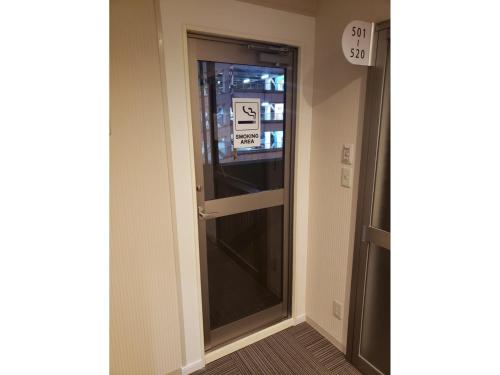 熊本市にあるHOTEL CARNA A - Vacation STAY 53728vの看板が貼られた廊下のガラス戸