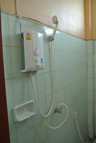 a shower in a bathroom with a hose on the wall at Dalom Guesthouse in Don Det
