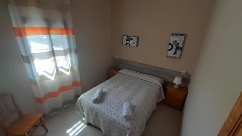 a small bedroom with a bed and a window at Camping las Catalinas in Ríolobos