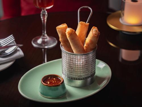 a container of breadsticks on a plate on a table at Hyatt Pune in Pune