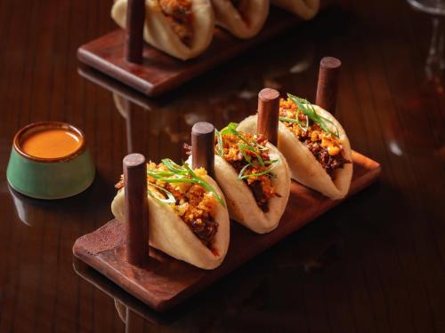 a group of four hot dogs on plates on a table at Hyatt Pune in Pune