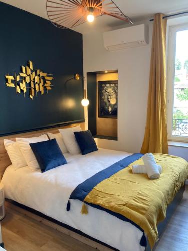 une chambre avec un grand lit avec des oreillers bleus et blancs dans l'établissement Résidence La Provence - Appartements Proches centre ville, à Vichy