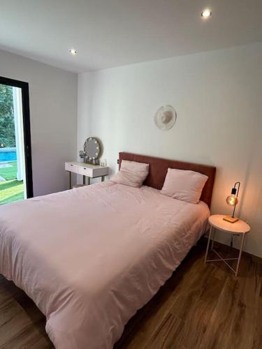 une chambre avec un grand lit blanc et une table dans l'établissement Villa Catalya moderne piscine chauffée, à Carcassonne