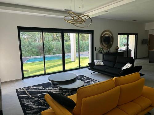 un salon avec un canapé et une table dans l'établissement Villa Catalya moderne piscine chauffée, à Carcassonne