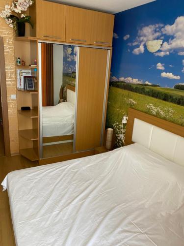 una camera da letto con un letto e un grande specchio di Апартамент на солнечном берегу a Sunny Beach