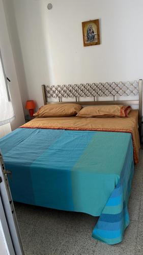 een slaapkamer met een bed met een blauwe sprei bij dg.apartaments in Alcamo