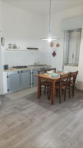 een keuken met een houten tafel en stoelen. bij dg.apartaments in Alcamo