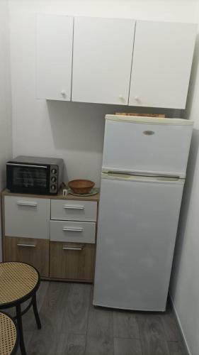 een keuken met een witte koelkast en een tafel bij dg.apartaments in Alcamo