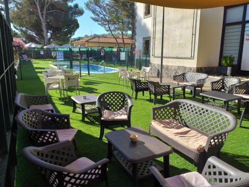 un patio con mesas y sillas y una piscina en Camping las Catalinas, en Riolobos
