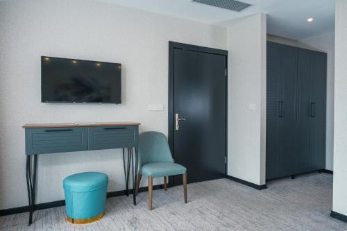 a room with a desk and a chair and a tv at Leo Suites in Bursa