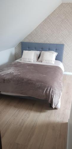 un grand lit avec une tête de lit bleue dans une chambre dans l'établissement Les rias du bélon zébre, à Riec-sur-Bélon