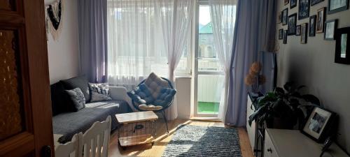 a living room with a couch and a large window at Retrospekcja - Apartament w centrum in Zakopane