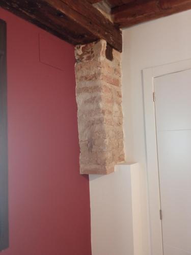 a brick wall in a room with a door at SEÑORÍO DE ORGAZ III in Toledo