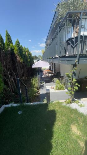 a yard with a building with a patio and grass at ROSMARIN - Kuschelige Fewo - Romantik & Entspannung im Whirlpool auf privater Terrasse, Ruhe & Hund willkommen - by FerienWohnenAmSee - in Überlingen