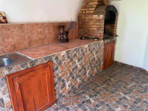 a kitchen with a stone counter top with a brick oven at Casa Izvorul Rece in Hobiţa