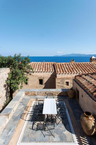 a table and chairs sitting on top of a roof at Bastione Malvasia Hotel (ex New Malvasia) in Monemvasia