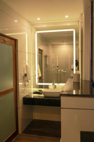 a bathroom with a sink and a large mirror at Villa Sasha By Elixir Cliff in Varkala