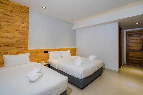 a bedroom with two beds with white sheets at Lek Lek Samui Room X Coffee Bar in Chaweng
