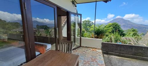 a room with a balcony with a view of a mountain at The Kayuan in Kintamani