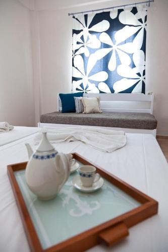 a glass tray with a vase and a cup on a table at Raisakis Apartments in Agia Marina Nea Kydonias