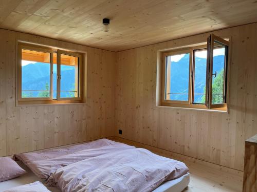 a bedroom with two windows and a bed in it at Sunnehuesli in Braunwald